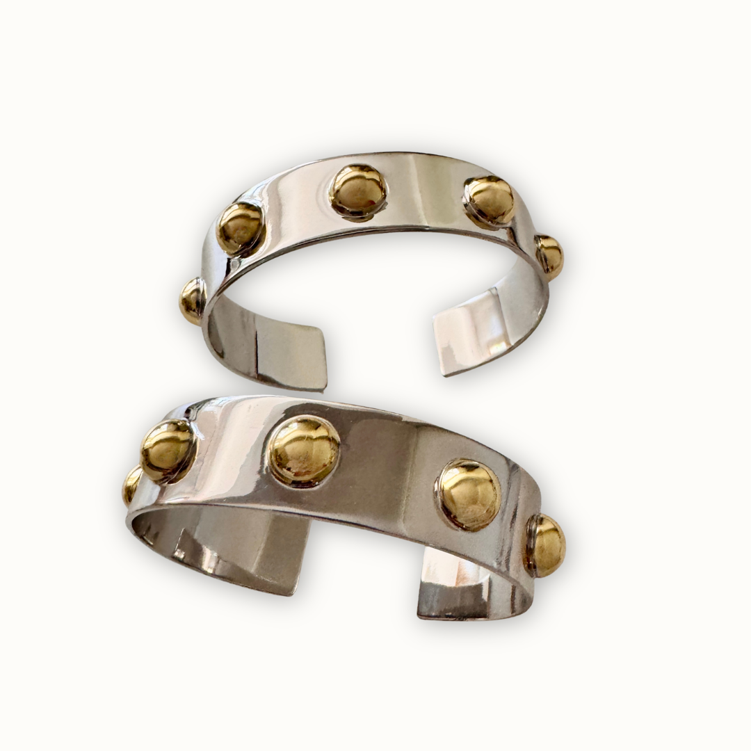 Sculptural silver Roman cuff bracelets with polished gold-tone dome accents 