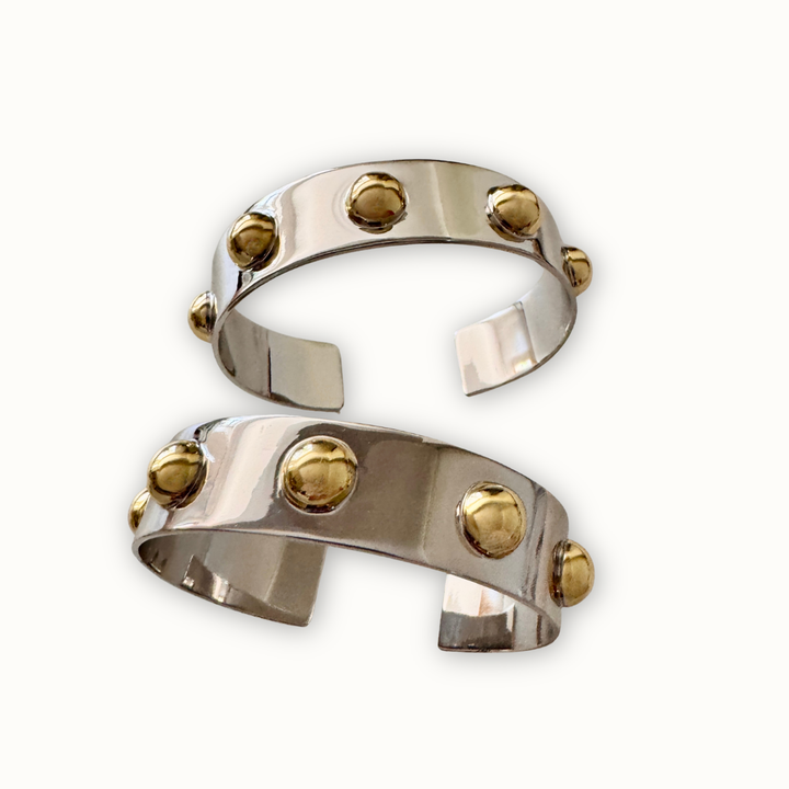 Sculptural silver Roman cuff bracelets with polished gold-tone dome accents 
