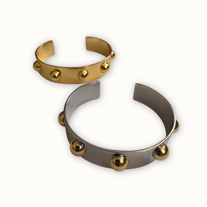 Mixed metal Roman cuff bracelets in silver and gold tones with sculptural design 