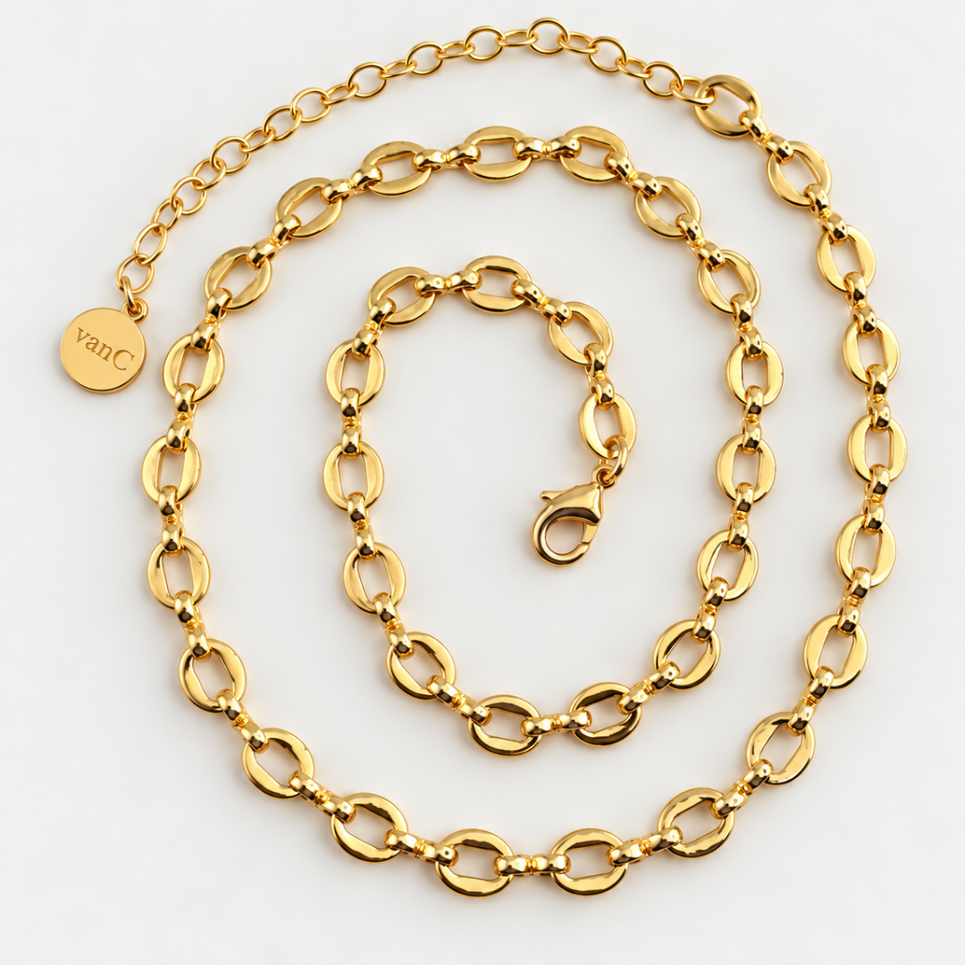 Boho big loop chain from Blauw van C with elongated oval links, coiled on a white background. It features a lobster clasp, an adjustable chain extension with a small round tag engraved with 'vanC'.