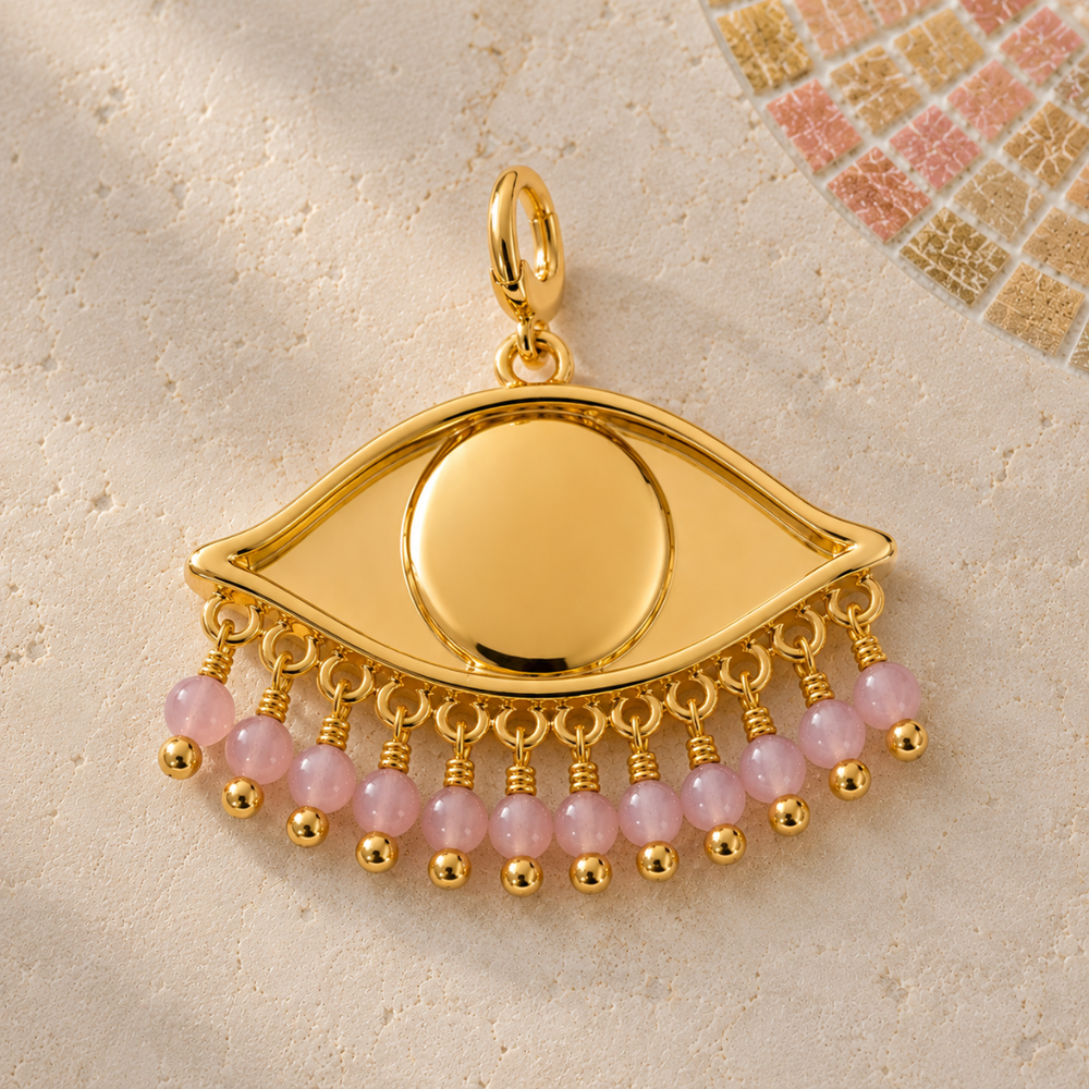 See the World Charm in Sakura Pink, 18k Gold plated eye shaped pendant with pink beads on a stone with mosaic background.