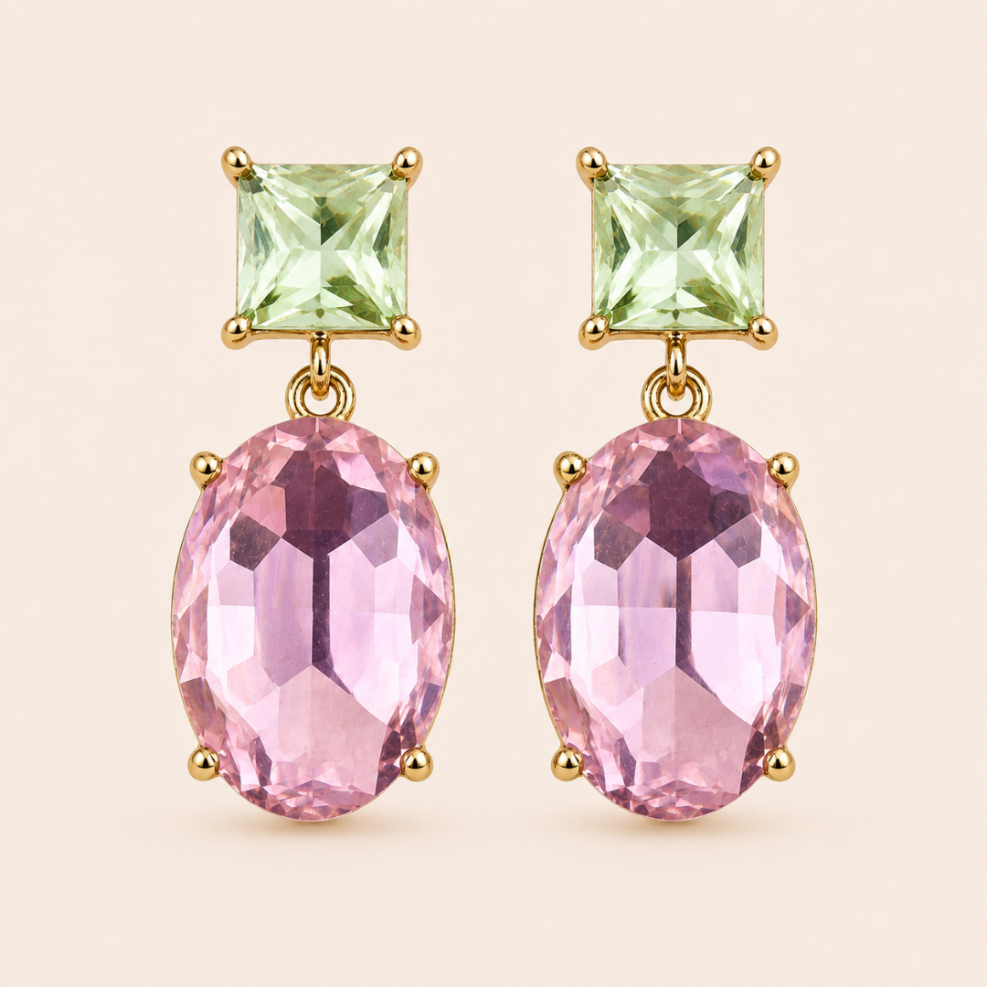 Two way glow Crystal  drop earrings with a square light green crystal on the top and a larger faceted oval light pink crystal on the bottom, set in 18K gold plated,  against a neutral  background.