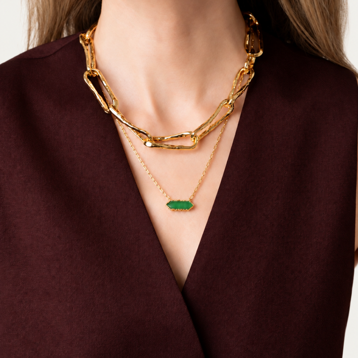 Blauw van C Andalus Necklace in Granada Green, layered with a chunky gold chain on a model wearing a tailored burgundy waistcoat.