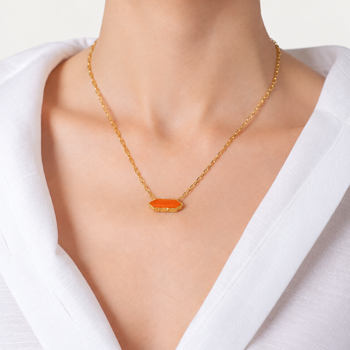 Blauw van C Andalus Necklace in Seville Orange, worn with a white shirt, showing the geometric shaped agate pendant and 18K gold-plated link chain.