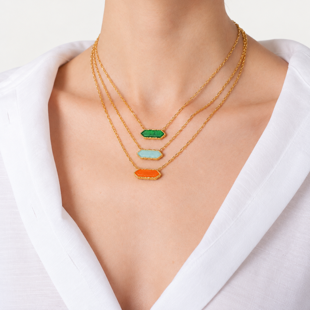 Blauw van C Andalus necklaces in Granada Green, Cadiz Blue and Seville Orange, worn at three lengths with a white shirt.